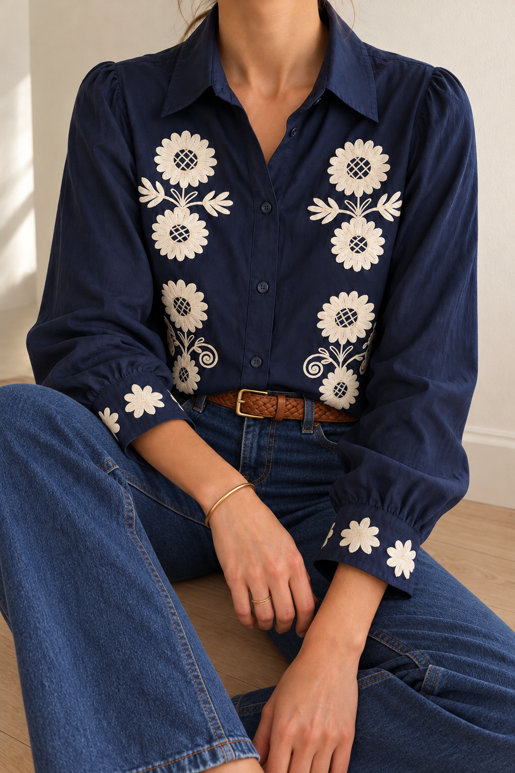 Chemise Nelia brodée marine, jean bleu et ceinture tressée camel — vue assise